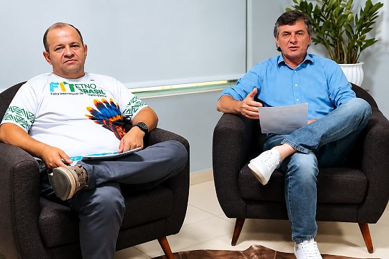 Prefeito de Campo Novo do Parecis e secretário de Turismo, de camiseta da FIT Etno Brasil, sentados em poltronas