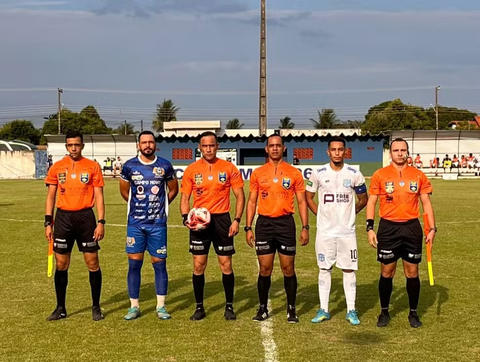 Capitães de Campo Novo, de uniforme azul, e do Cacerense, de branco, posam com o trio de arbitragem antes do jogo no Estádio Ary Tomazelli