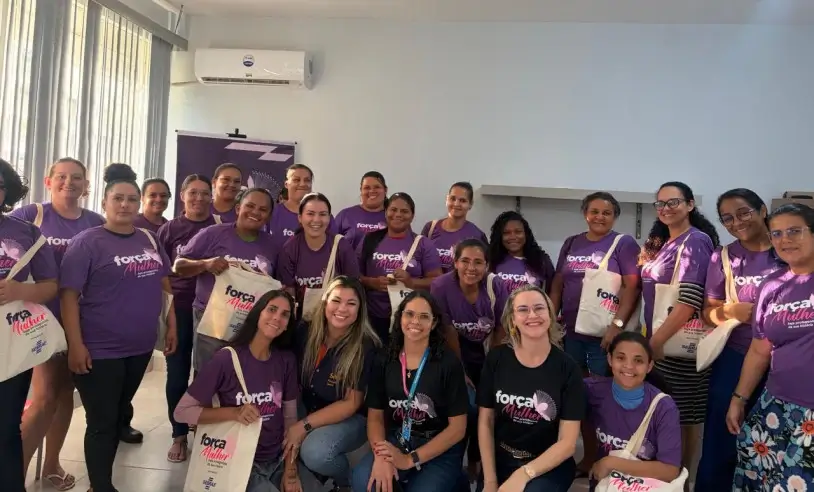 Participantes do Projeto Força Mulher, de camiseta roxa, posam juntas em sala de aula em Campo Novo do Parecis