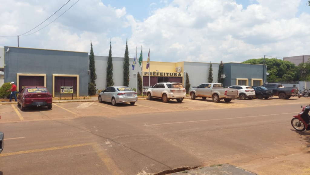Fachada da Prefeitura de Brasnorte com carros estacionados em frente e bandeiras hasteadas
