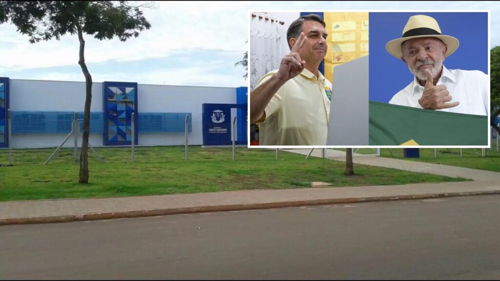 Fachada azul e branca da Escola Estadual Argeu Augusto de Morais, no Distrito Itamarati Norte, com miniatura das fotos de Flávio Bolsonaro e Lula no canto superior direito